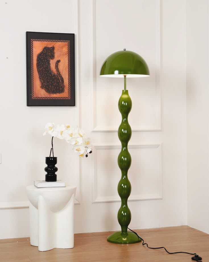 Modern black mushroom floor lamp with sculptural base and dome shade in a contemporary living room interior.