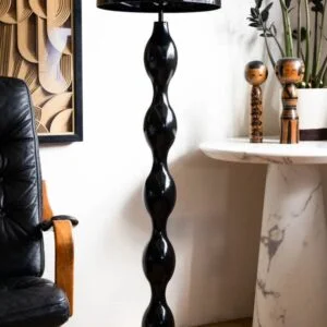 Modern black mushroom floor lamp with sculptural base and dome shade in a contemporary living room interior.
