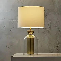 Tofty glass table lamp with elegant transparent base and fabric shade for modern interior lighting.