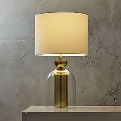 Tofty glass table lamp with elegant transparent base and fabric shade for modern interior lighting.